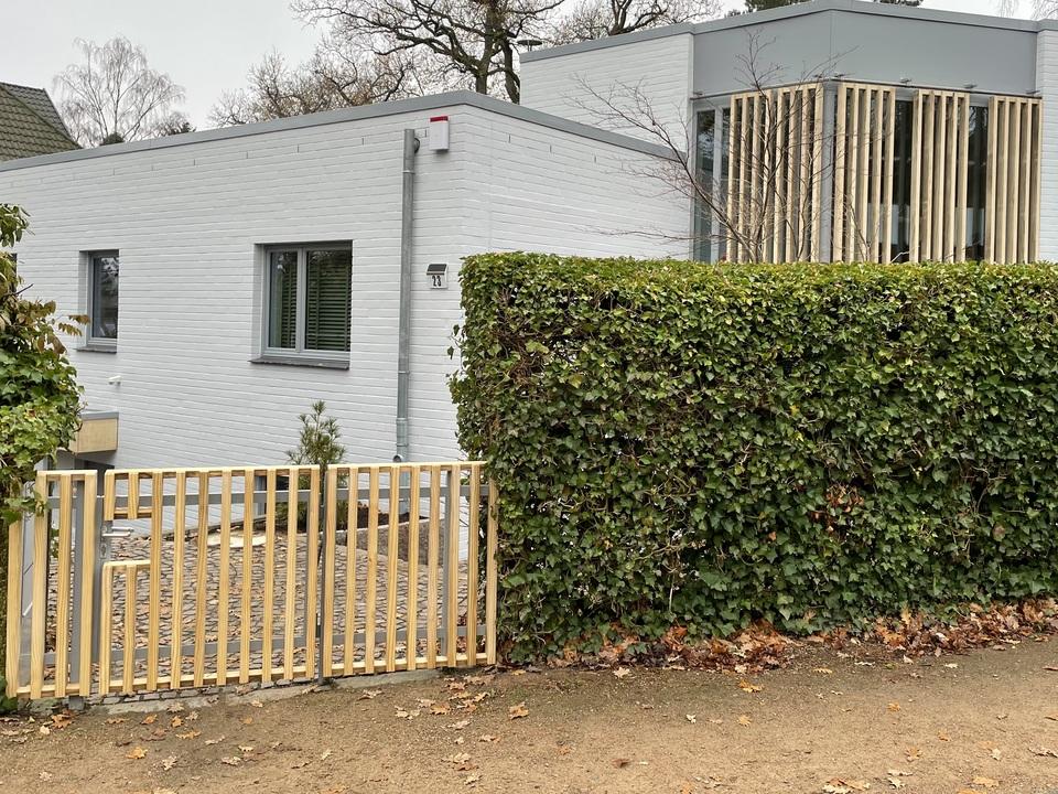 Fassade mit vertikalen Holzlamellen vor gro&szlig;fl&auml;chigen Fenstern