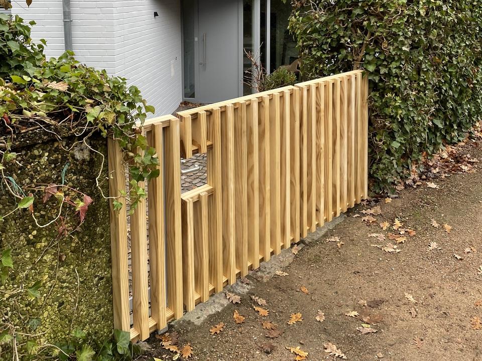 Holztor und Lamellen-Fassade an einem modernen Einfamilienhaus
