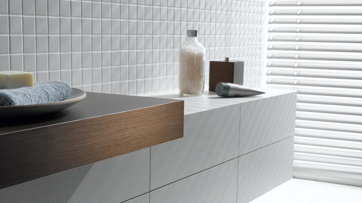 Detailaufnahme eines weißen Waschtischunterschrankes mit dunkler Waschtischplatte