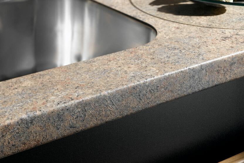 Detailaufnahme einer Küchenarbeitsplatte mit Spüle und verschiedenen Holzelementen Detailaufnahme einer Küchenarbeitsplatte mit Edelstahlspüle und verschiedenen Holzelementen: schwarz lackiert, naturbelassen und Steinoptik