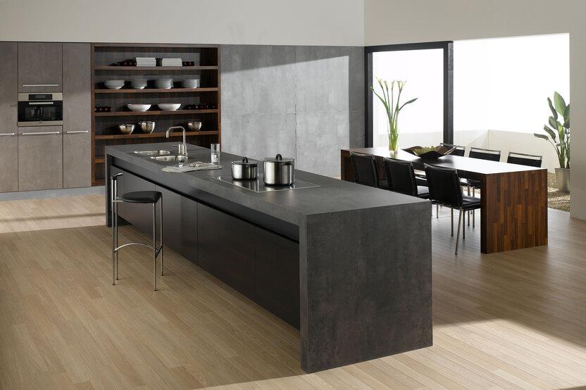 Küchen- und Esszimmerimpression mit einer Kombination aus Holz- und Stein-/ Betonoptik und Einbauschränken
