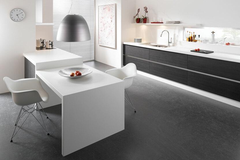 Impression einer Küchengestaltung mit Essplatz für Zwei Impression einer einzeiligen Küchengestaltung in schwarz-weiß mit Esstisch für Zwei