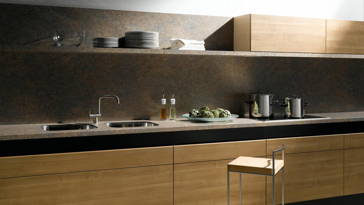 Küchenzeile aus Massivholz mit schwarzer Arbeitsplatte, Spülbecken und Wandregal