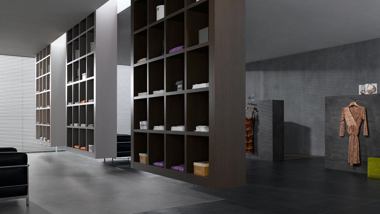 Impression eines geräumigen Regalsystems aus dunklem Holz in einem hochwertigen Bekleidungsladen