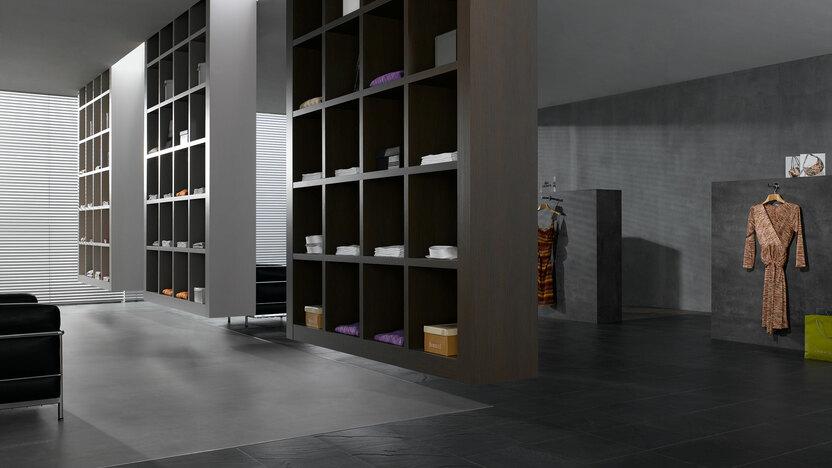 Impression eines Regalsystems in einem Bekleidungsladen Impression eines geräumigen Regalsystems aus dunklem Holz in einem hochwertigen Bekleidungsladen