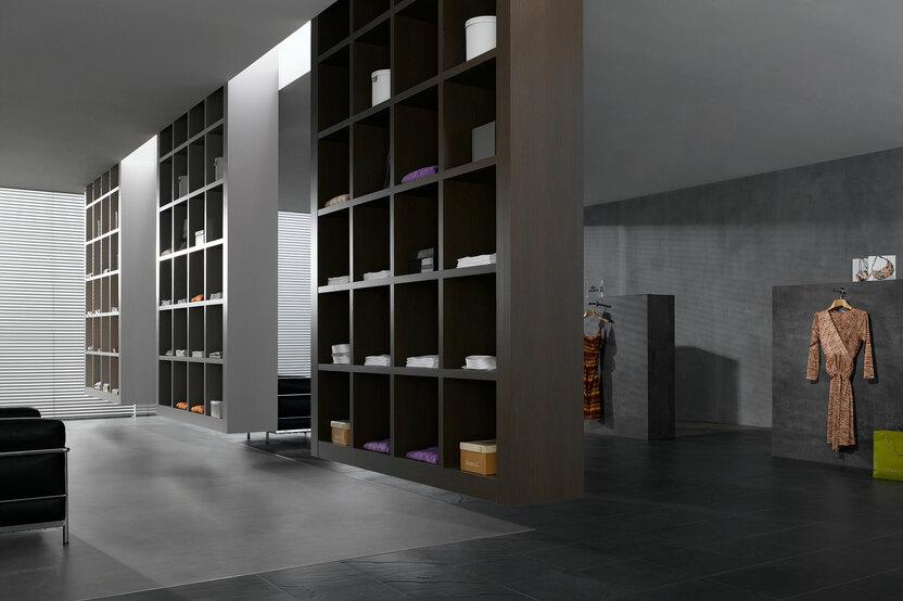 Impression eines Regalsystems in einem Bekleidungsladen Impression eines geräumigen Regalsystems aus dunklem Holz in einem hochwertigen Bekleidungsladen